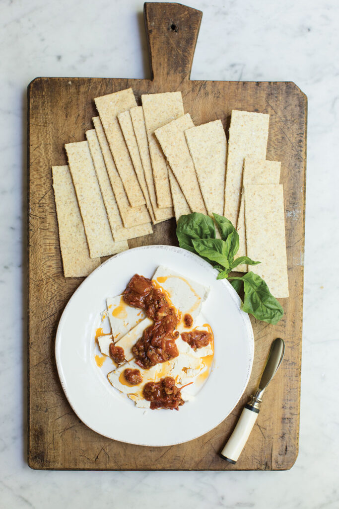 Plate of marinated cheese on a wooden cutting board