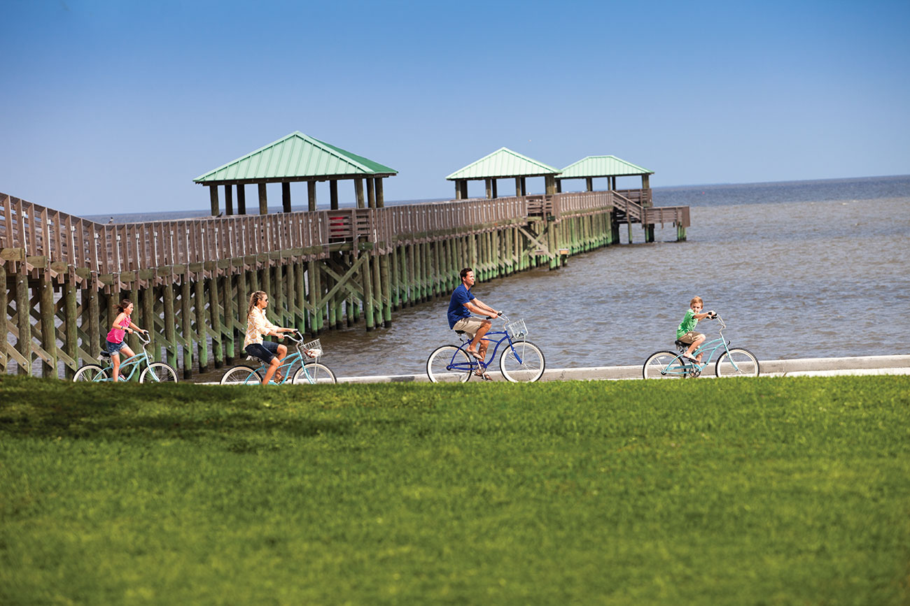 Family biking along the beach in Ocean Springs