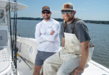 two men sitting on a fishing boat