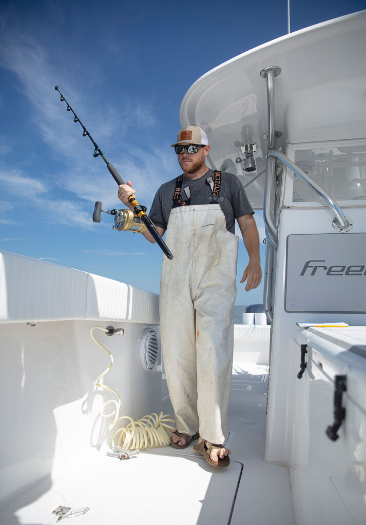 Man holding a fishing pole on a boat