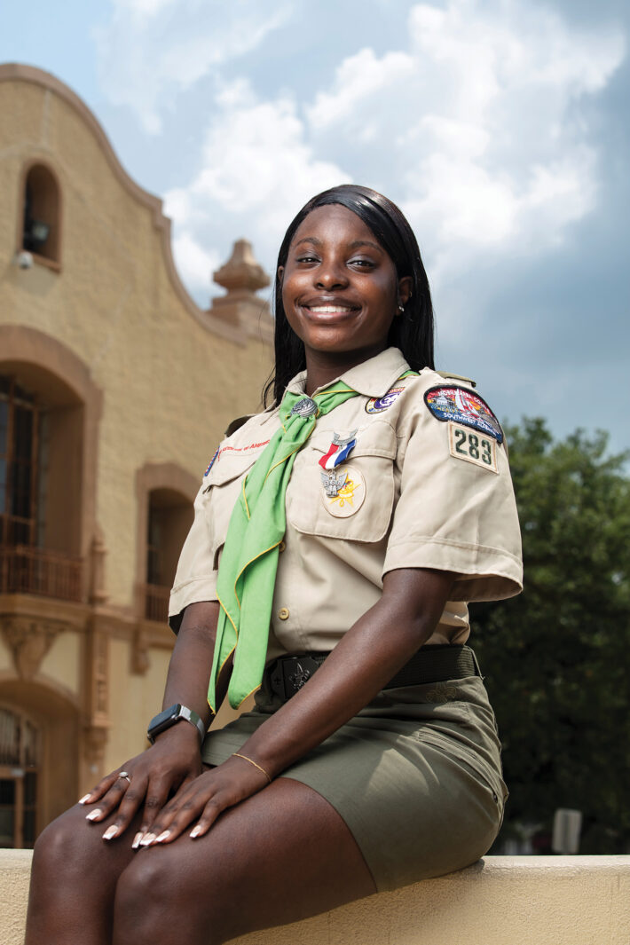 Female Eagle Scout dressed in uniform posed in front of school