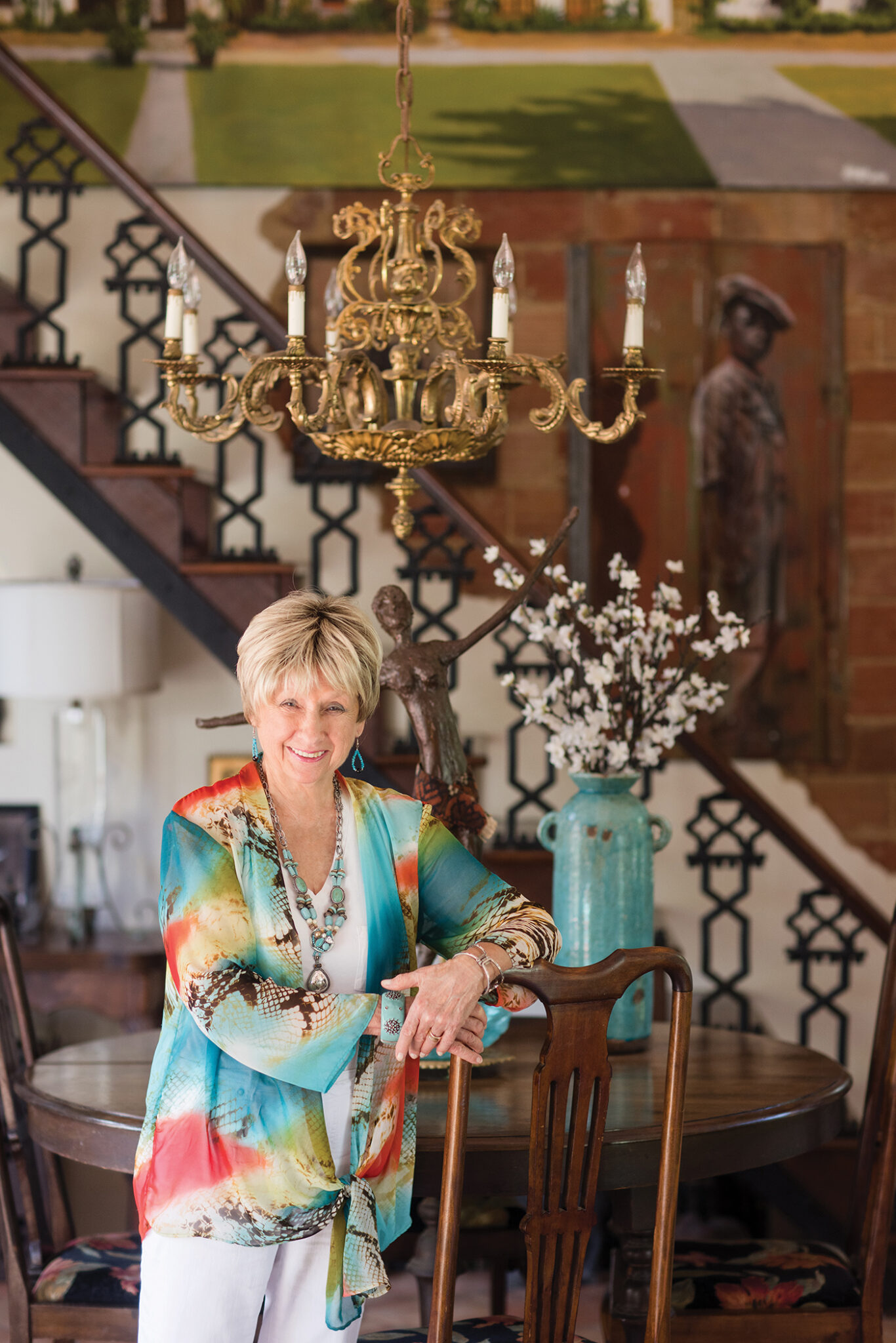 Camille Turner Standing beneath her antique chandelier