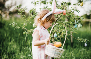 little girl holding a basket during an April Easter Egg hunt