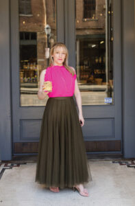 Lauren McGowan of Lohibition holding a non-alcoholic cocktail in front of her store.