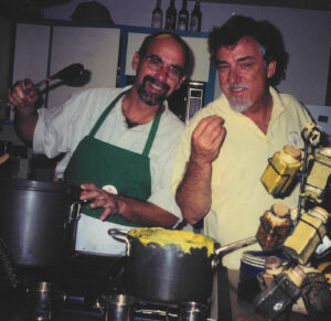 A photograph of Dr. Bob Shipp and John Dindo cooking in a kitchen.