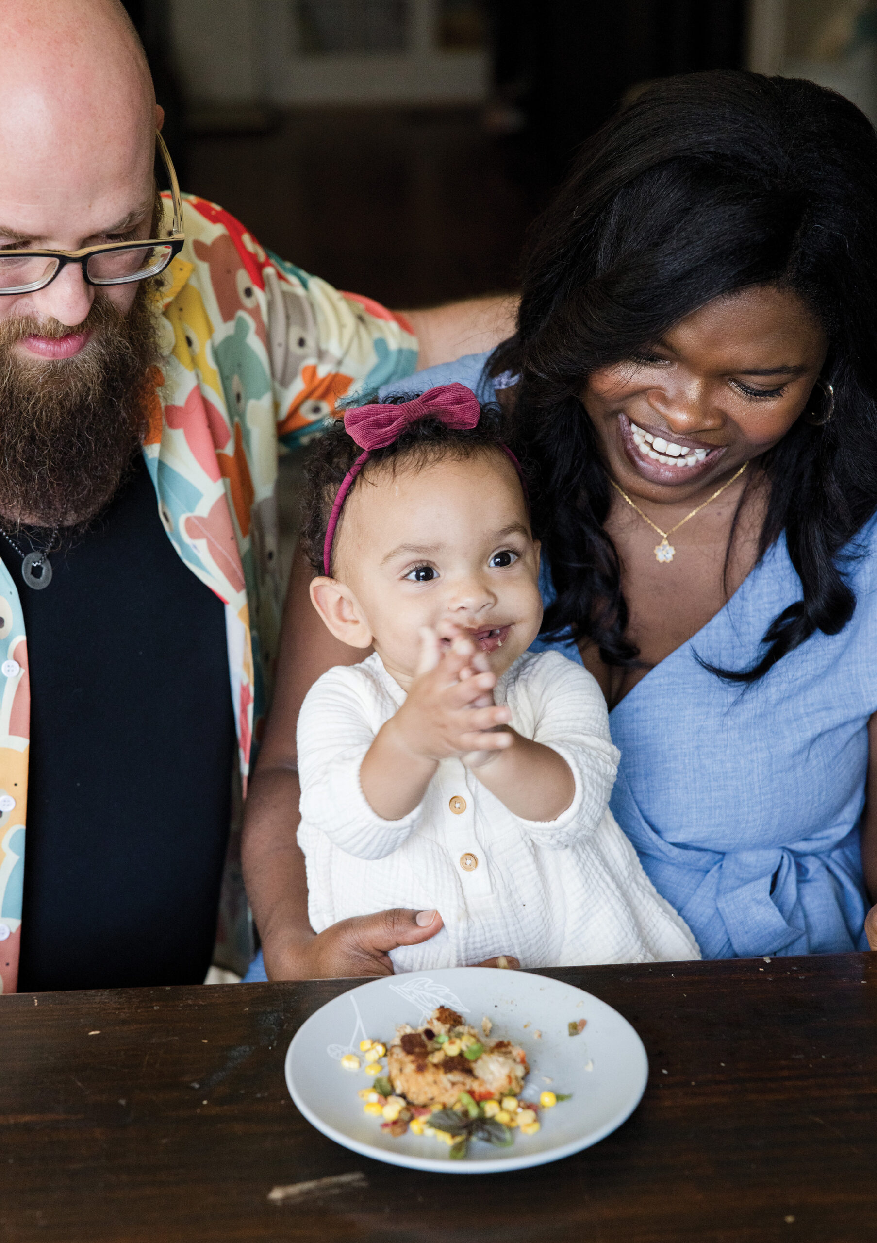 Rob Varner and his wife hold their young daughter while sitting at the dining table