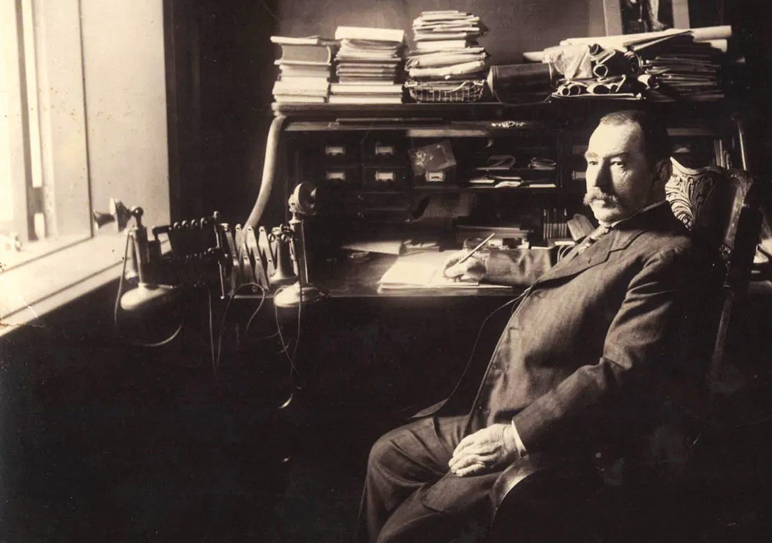 Pat Lyons seated at his desk