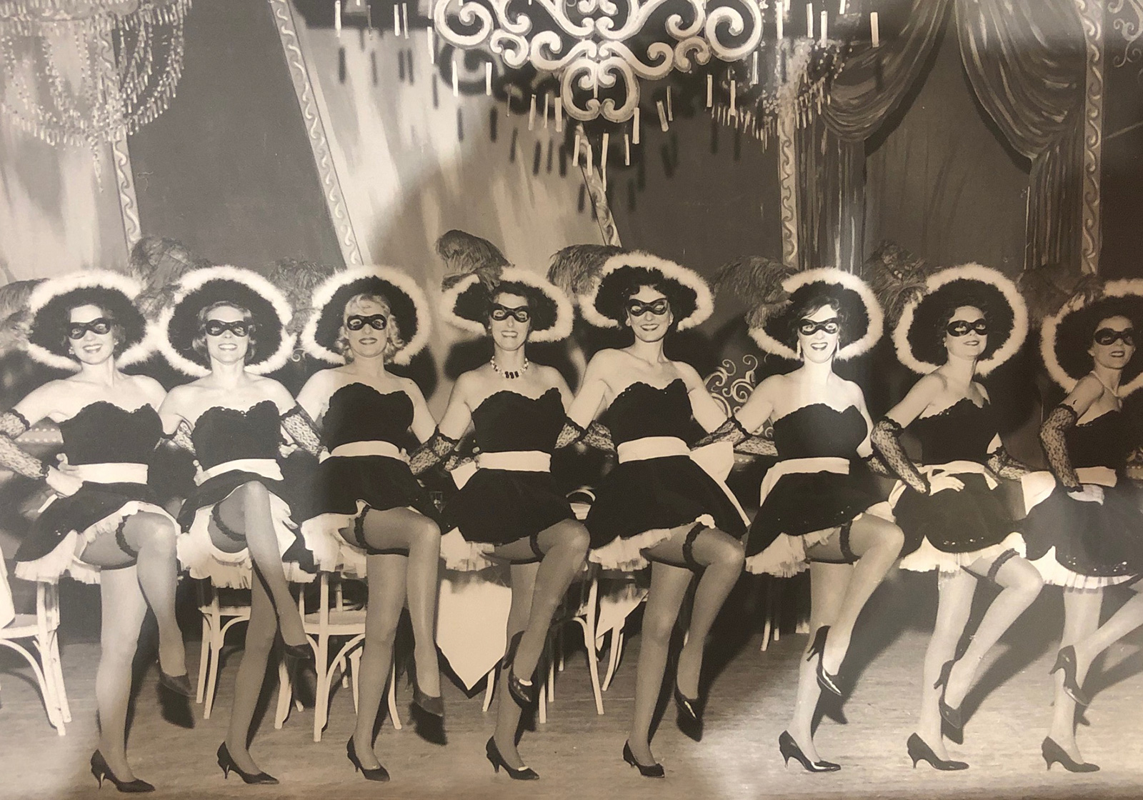 Women dressed in costume in a kick line at a ball for The sirens